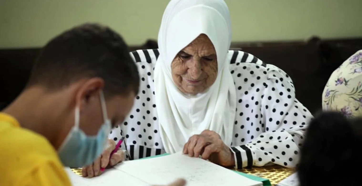 امرأة في عمر الثمانين تعلم الأطفال الرياضيات